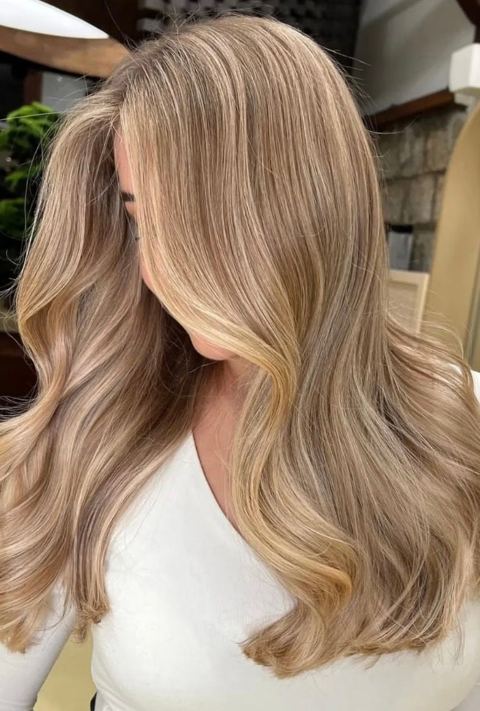 Lived-in blonde balayage with soft dimensional waves and a blended grow-out